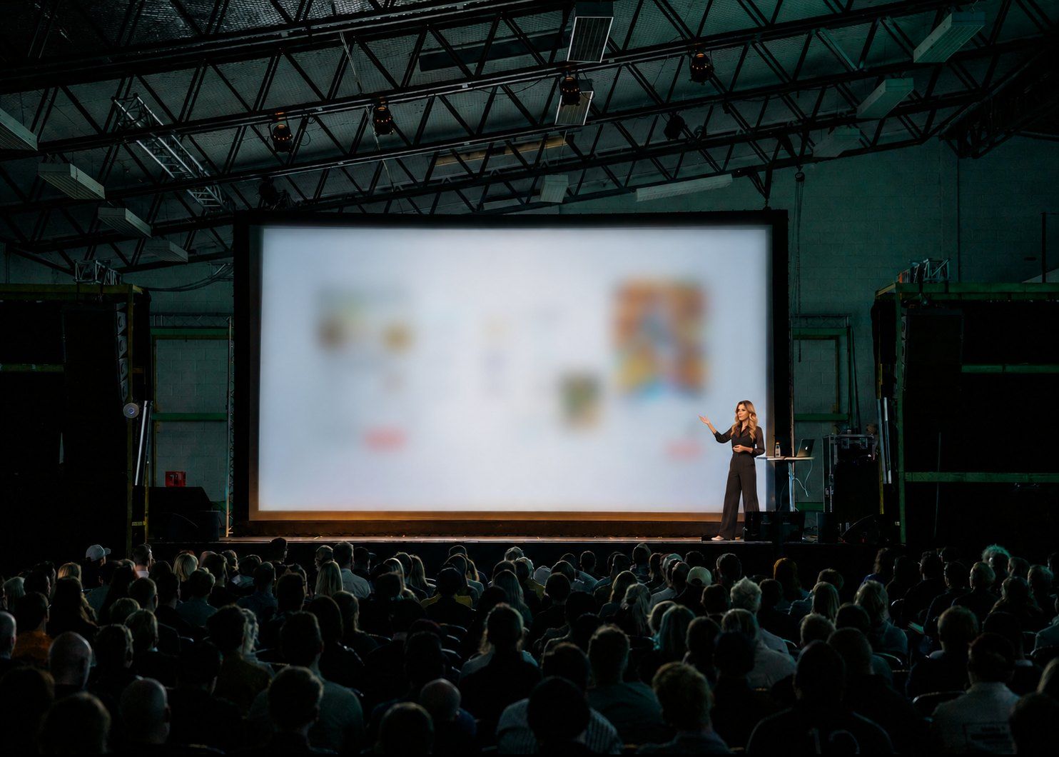 Amanda Khalaf presenting on stage to a full audience