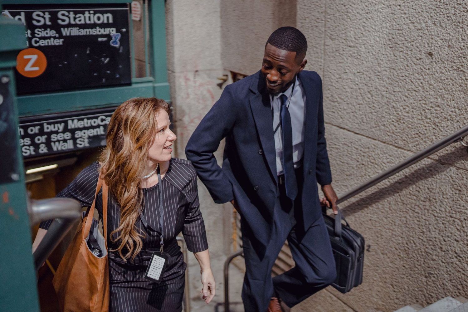 Two colleagues in conversation as they climb the steps out of a city station